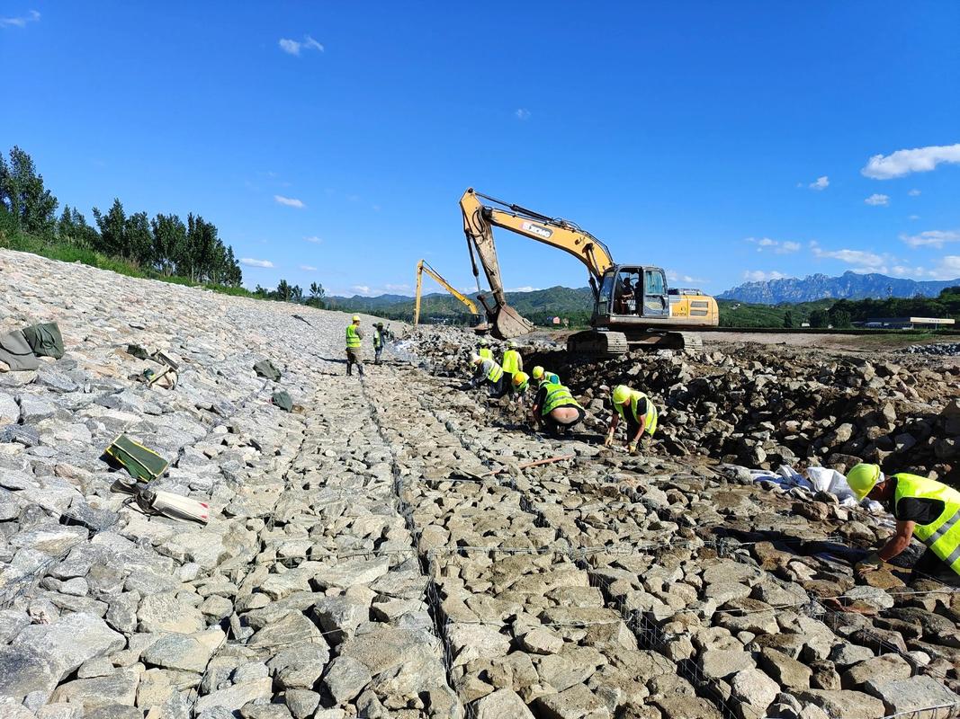 Large-scale gabion retaining wall construction with heavy equipment
